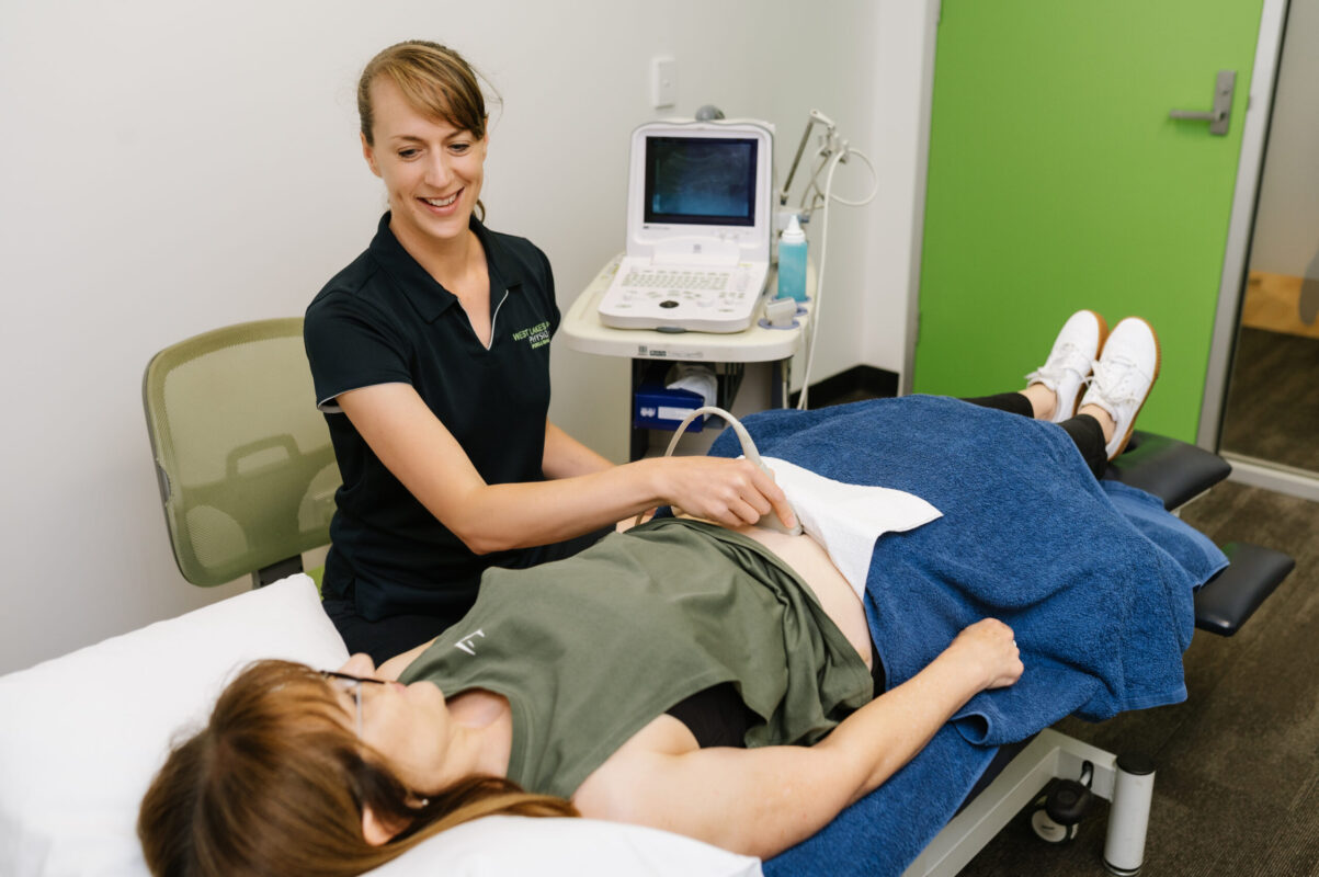 Women's health physio assessing pelvic floor function using ultrasound machine